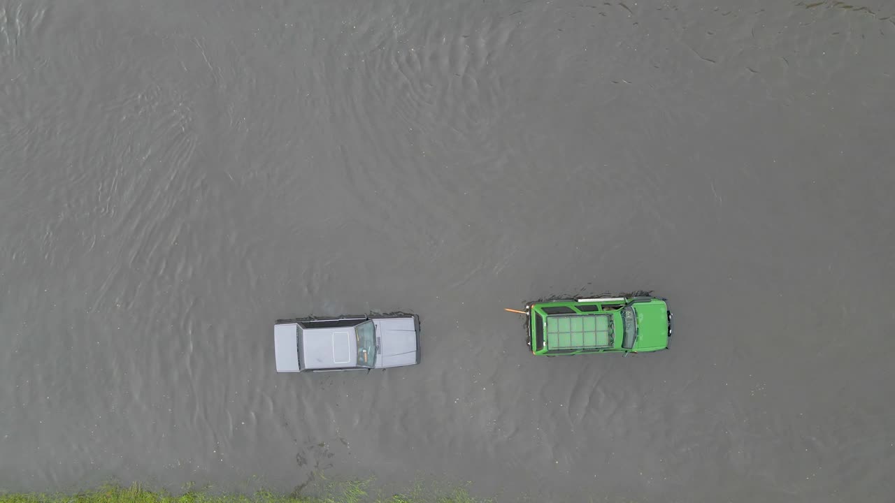 鸟瞰图的城市交通与汽车行驶在洪水后的街道。道路排水系统问题。视频素材