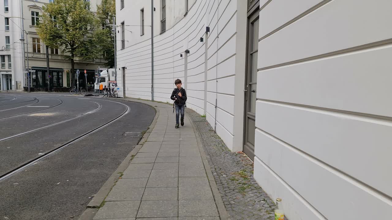 一个男孩戴着面具在去学校的路上在柏林的街道上视频下载