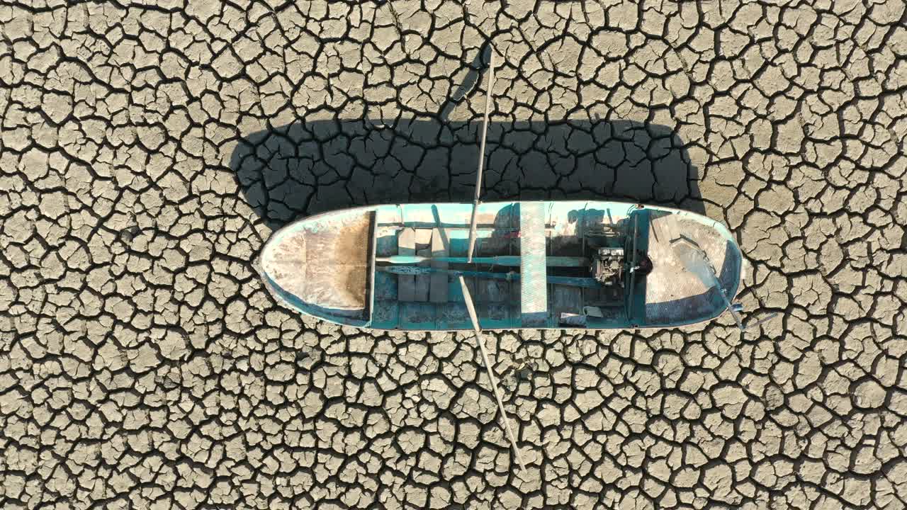 航拍的一艘渔船在干涸的湖床上。视频下载