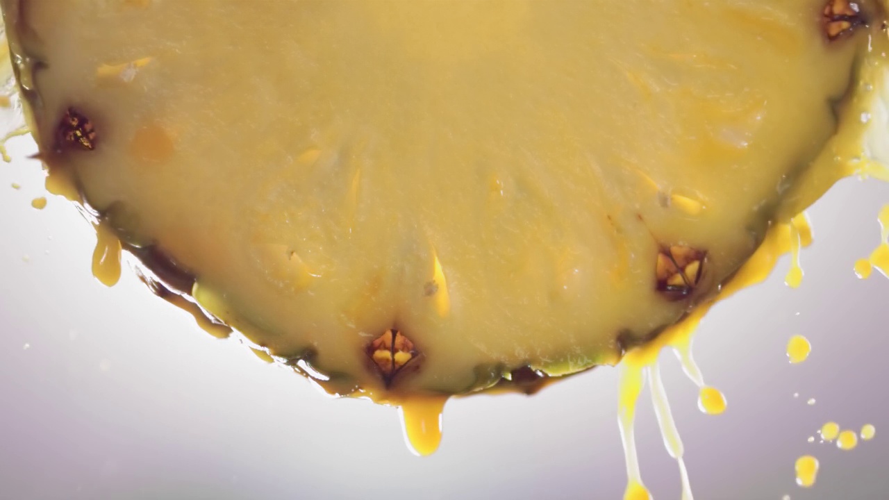 从菠萝片中流出的菠萝汁，微距慢镜头视频素材
