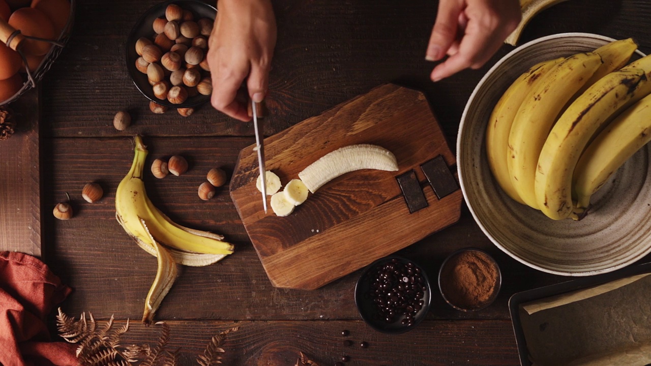 一个女人在厨房切香蕉的手的特写视频下载