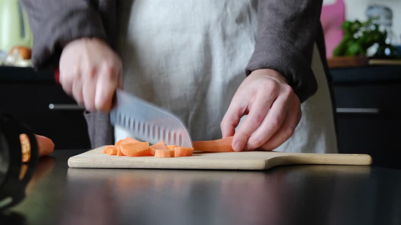 一个不知名的人正在切水果和蔬菜做排毒奶昔视频素材