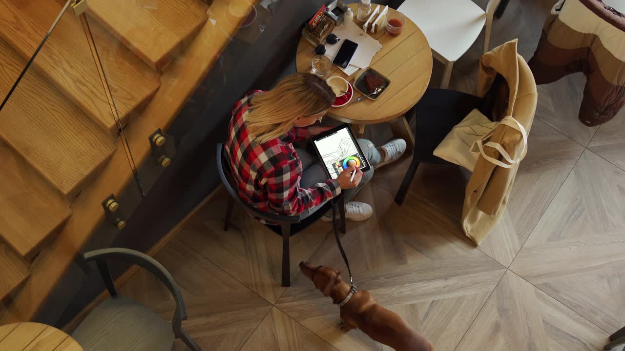 致力于现代女性平面设计师工作在平板电脑从咖啡店视频下载