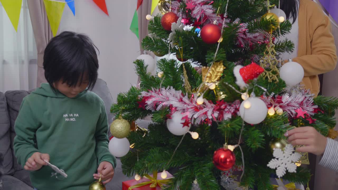 家人和兄弟姐妹在享受圣诞节的时光，孩子们在装饰圣诞树视频素材
