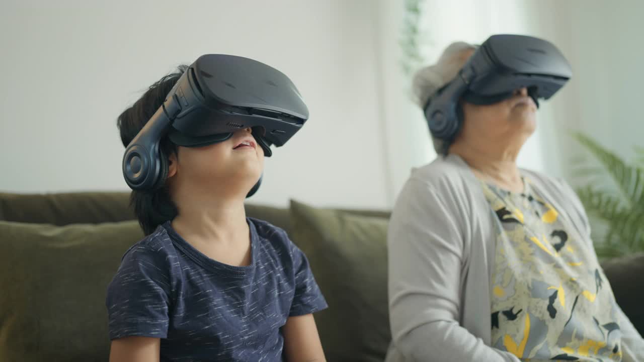 奶奶和孙子戴着VR玩游戏。视频下载