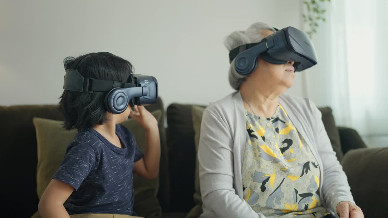 孙子和祖母在玩虚拟现实头盔。视频下载