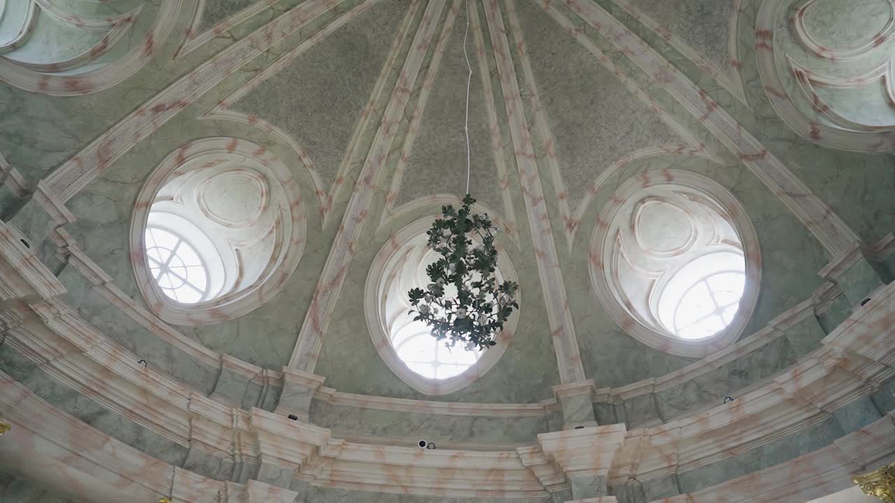 一盏大吊灯悬挂在一个宽敞的圆屋顶下。庙里射击视频素材