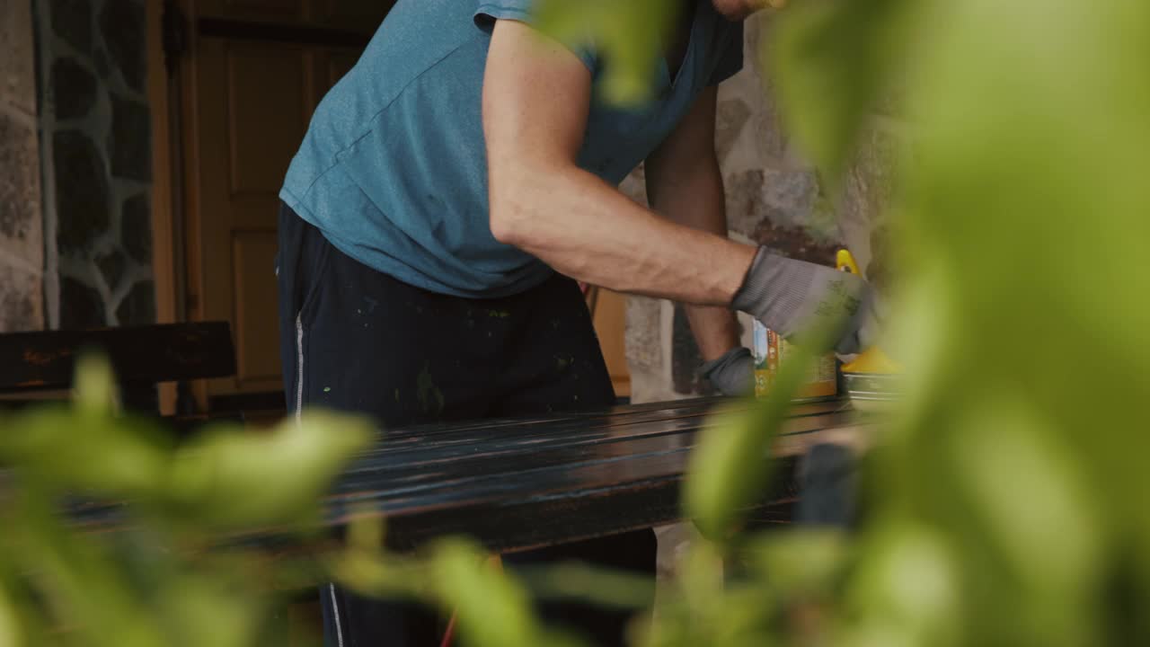 SLO MO Man油漆户外家具的木质表面视频下载