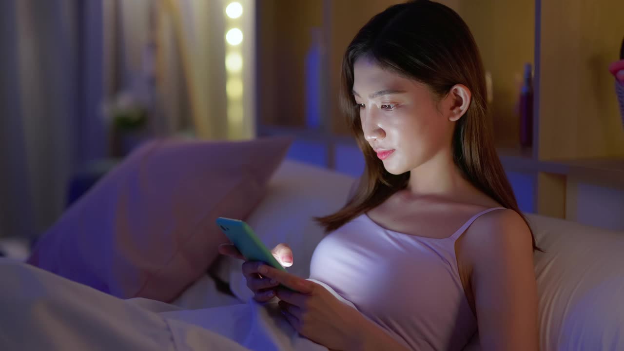 女人在床上用智能手机视频素材