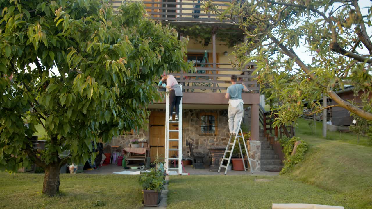 SLO MO夫妇在阳台上漆木栅栏视频素材