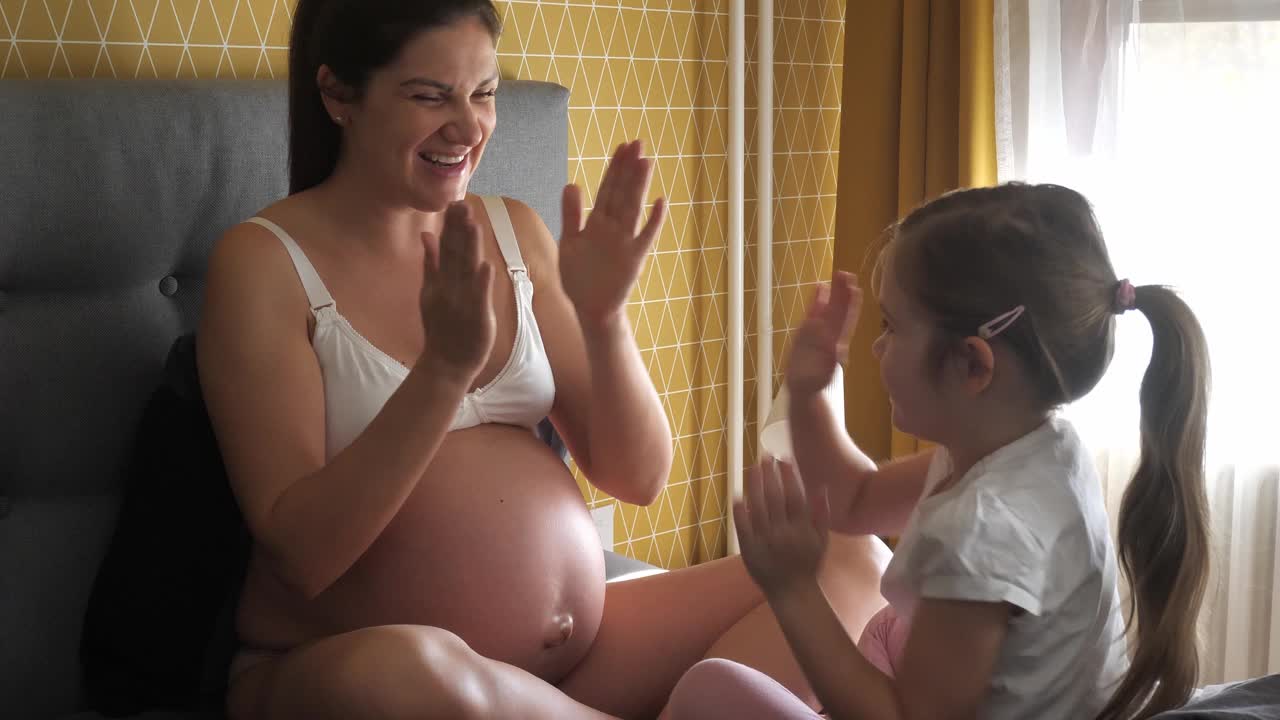 怀孕的中年妇女和女儿在玩耍视频下载