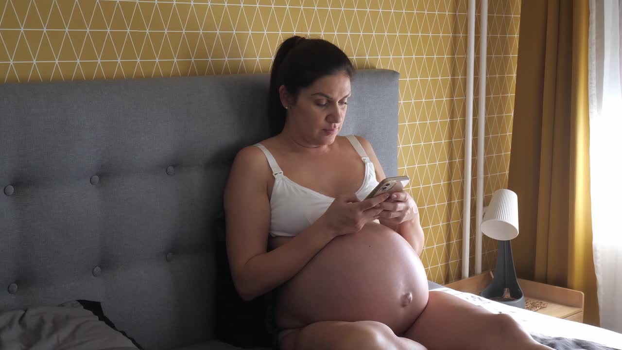 怀孕的中年妇女和女儿在家里打电话视频下载
