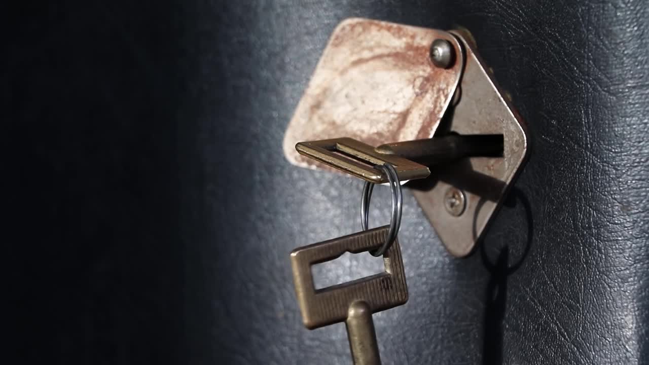 用钥匙把门关上。手握铜钥匙，打开门锁。黑色的门。钥匙被插在钥匙孔里。房子的安全。那只手转动钥匙。视频素材