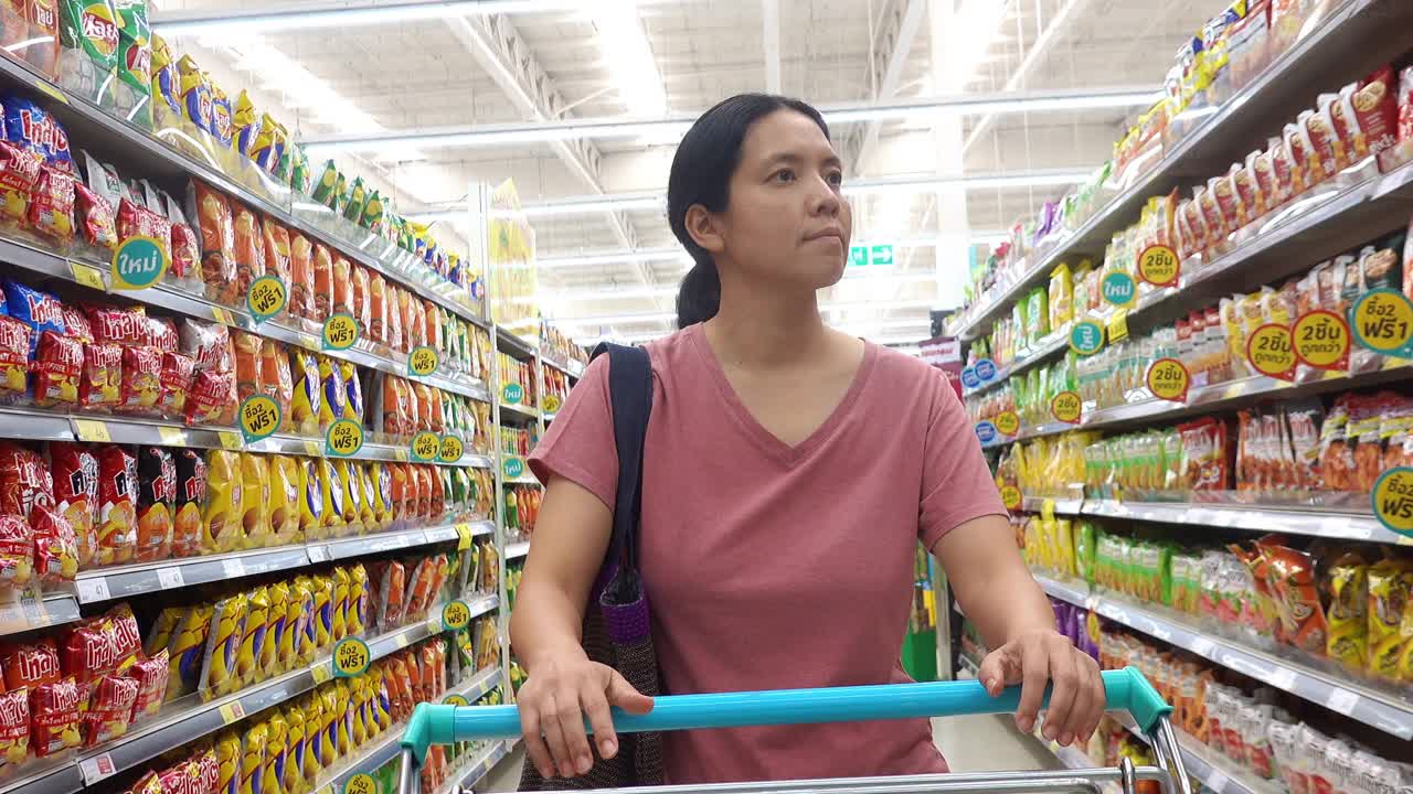 亚洲成熟女性在杂货店购物，用可重复使用的购物袋视频下载
