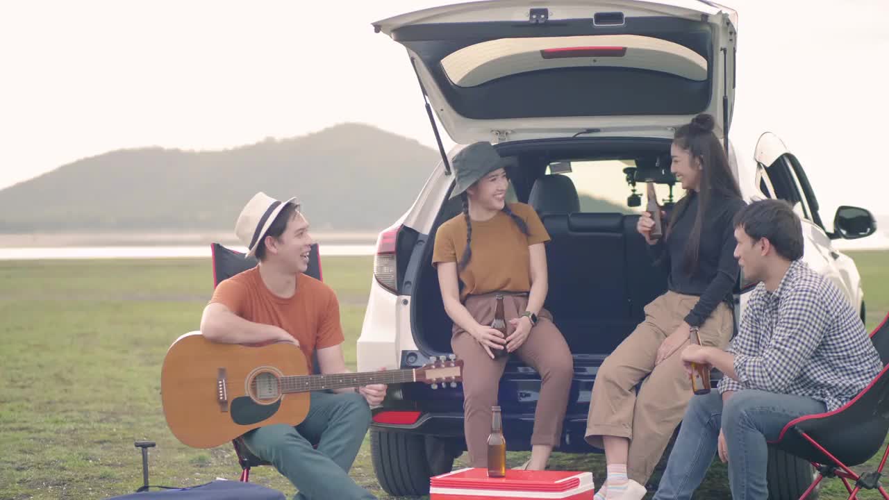 亚洲人和他们的亚洲朋友去大自然中露营。拿着一瓶饮料坐着视频下载