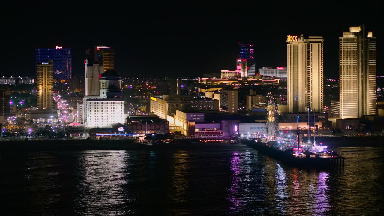 大西洋城市中心的海滨木板路，是美国东海岸著名的赌博中心，有多个赌场和码头上有摩天轮的游乐园。航拍视频与平移摄像机运动。视频下载