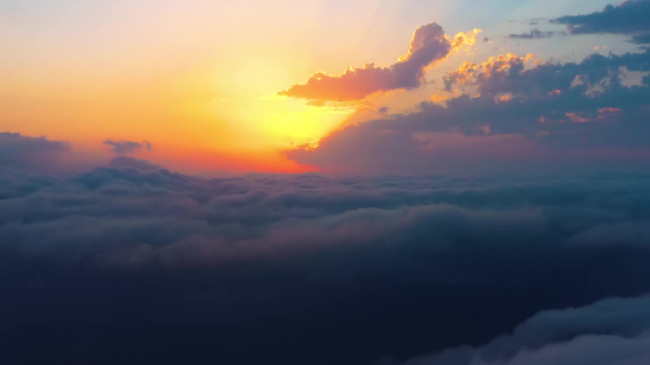 伴着夕阳在云上飞翔。日出或日落的彩色天空背景。视频素材
