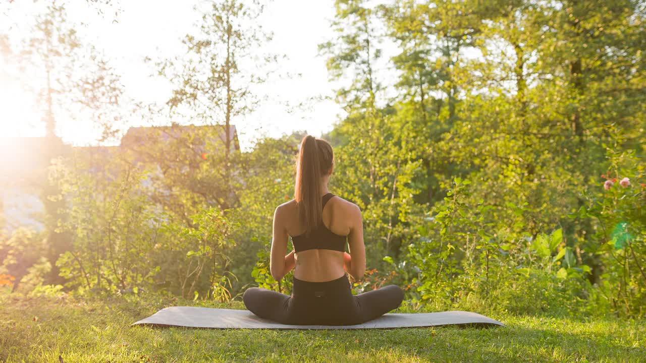 注重身体健康的女性，在户外的后院做瑜伽视频下载