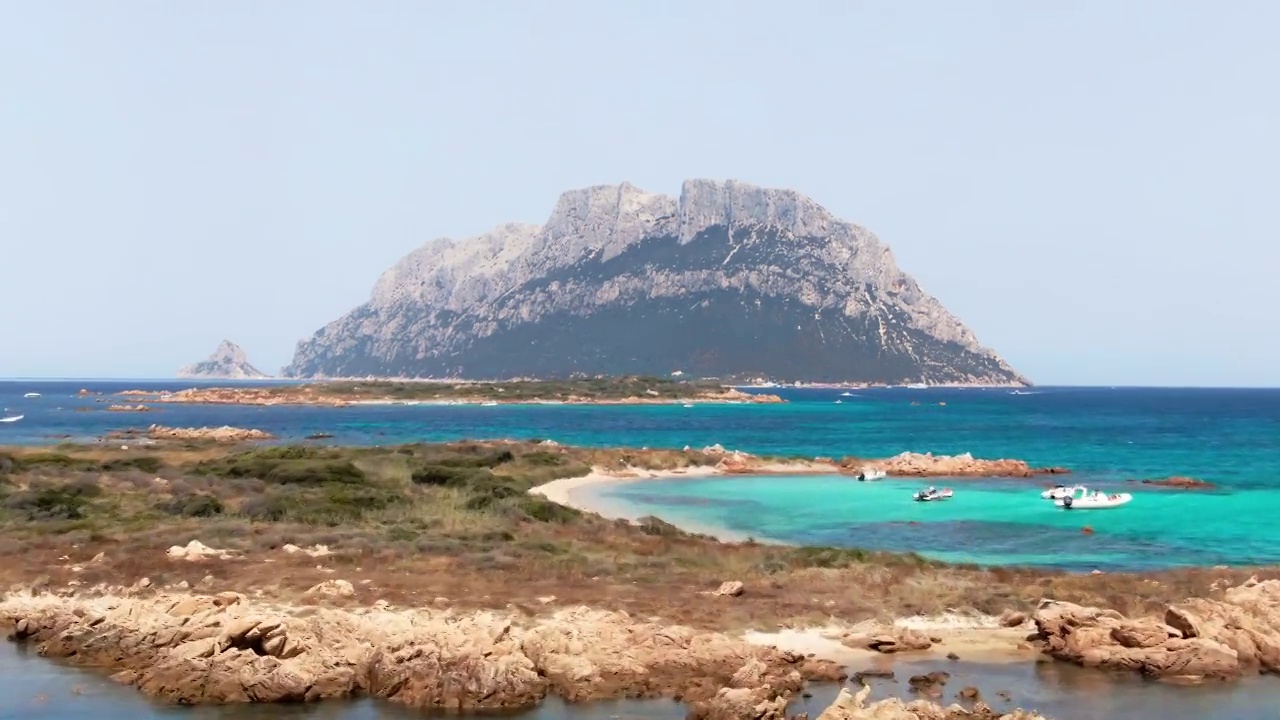 意大利撒丁岛的蓝色海水和小岛的鸟瞰图。伊索拉Tavolara岛。视频下载