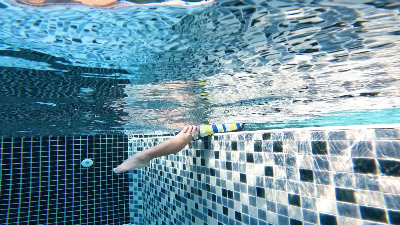 亚洲男孩在游泳池的水下玩耍和游泳视频素材