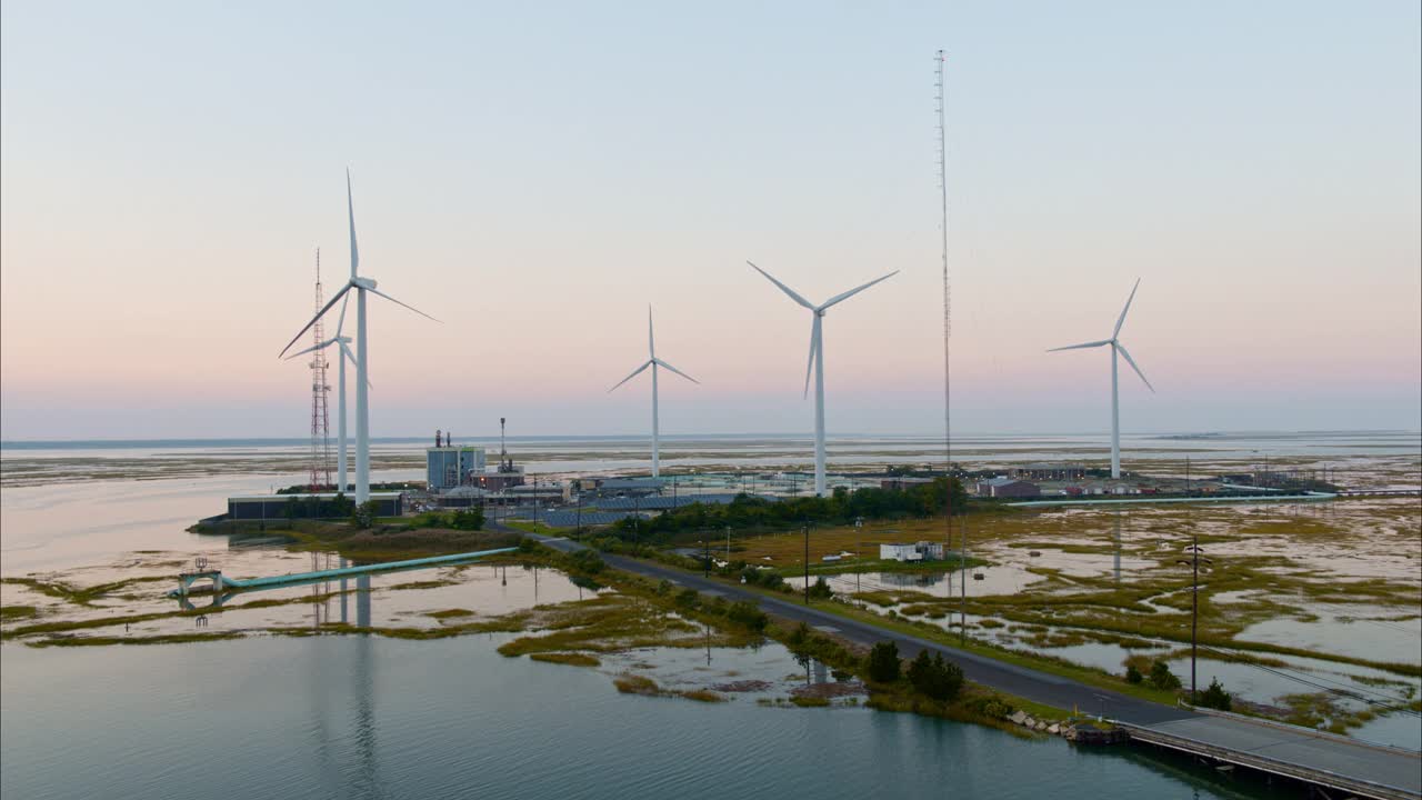 可持续能源用于环境保护。美国新泽西州大西洋城附近的一个由风力涡轮机和太阳能板供电的污水处理厂。航拍视频与平移摄像机运动。视频下载