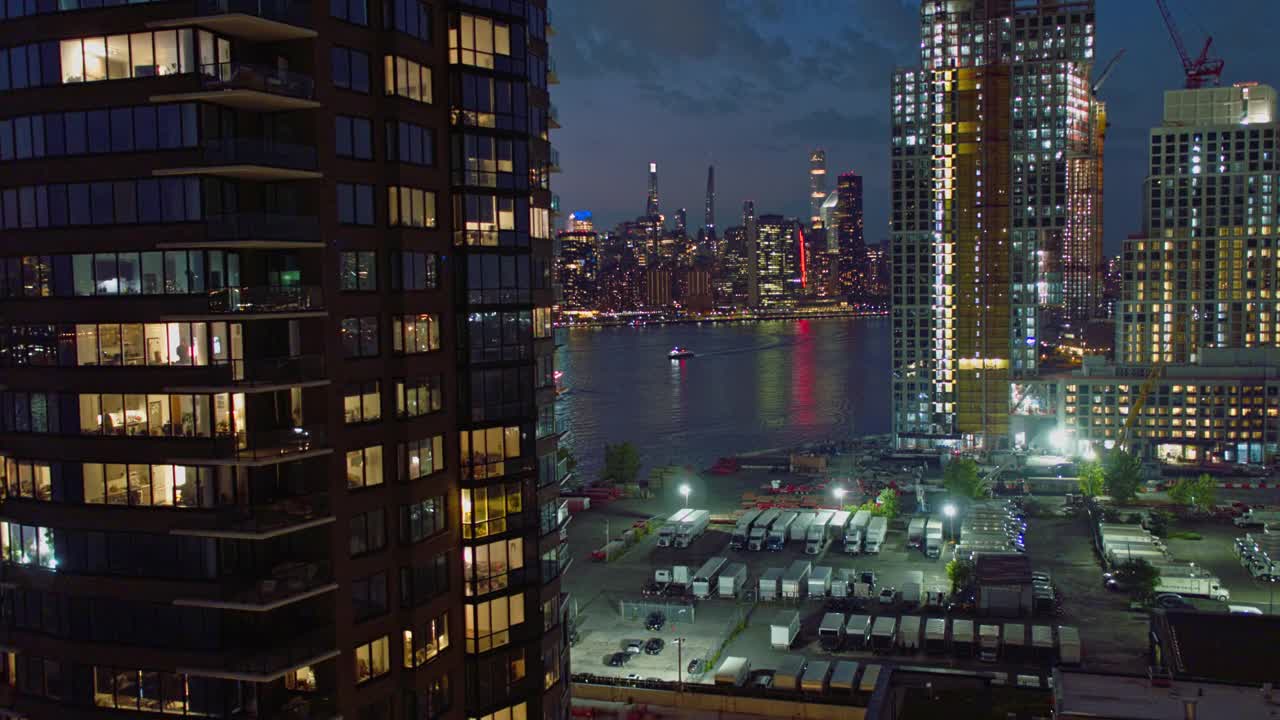 在布鲁克林绿点和皇后区猎人角的海滨，新建豪华公寓的夜景。航拍视频与后向摄像机运动。视频下载