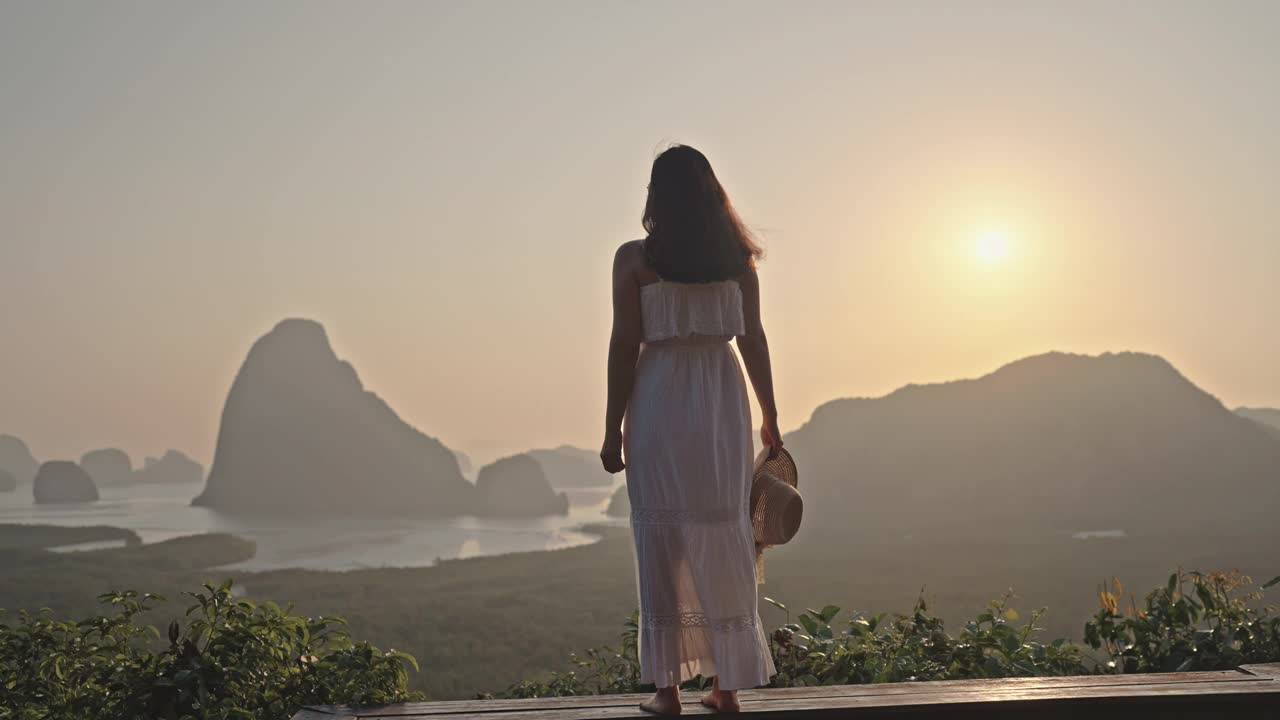 一名女游客站在山顶，欣赏令人叹为观止的日落美景视频素材
