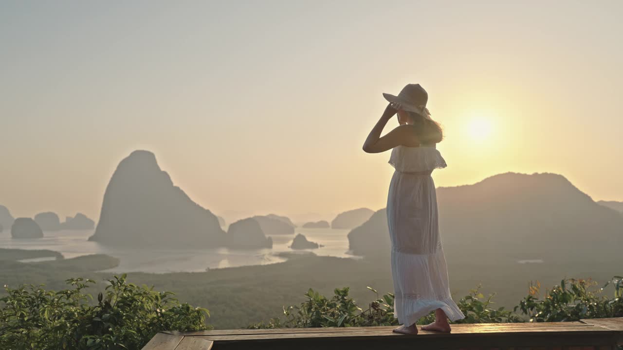 一名女游客站在山顶，欣赏令人叹为观止的日落美景视频素材