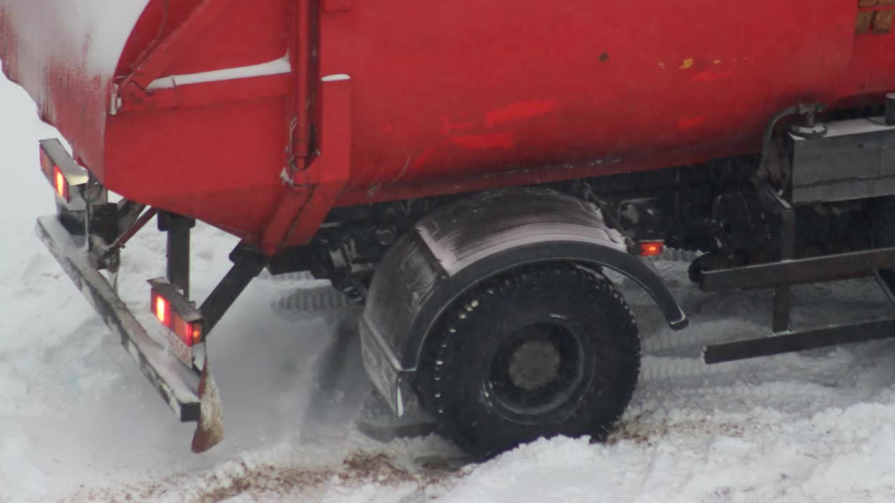 垃圾车在冬天的雪地里抛锚了。冬天轮胎在冰雪上打滑视频下载