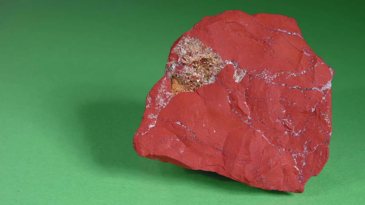 贾斯提克是红色的，绿色的背景。半珍贵的观赏石头。视频下载