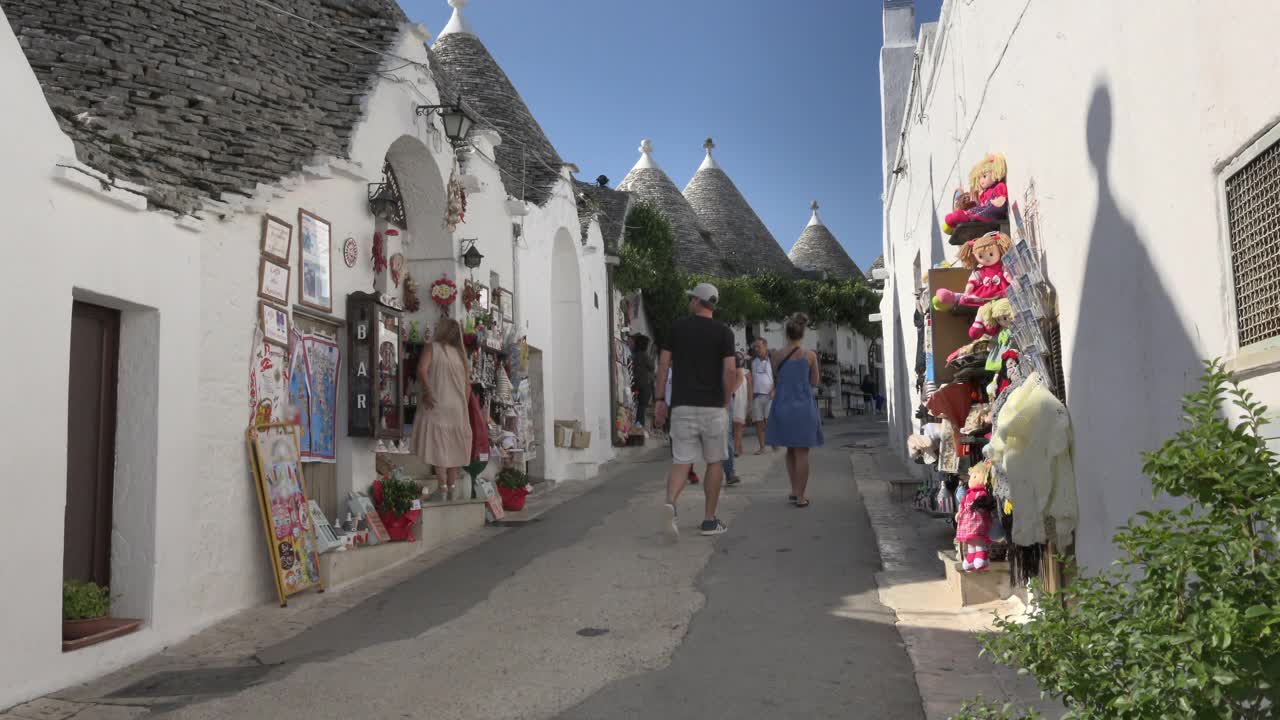 游客们走在一条有特鲁利房屋和礼品店的小巷里视频素材