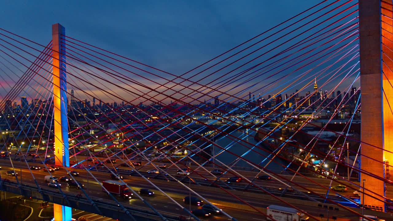 黄昏时分，灯火通明的Kosciuszko桥鸟瞰图，威廉斯堡工业区上方曼哈顿和布鲁克林的远景。无人机视频与电影复杂的全景后向轨道摄像机运动。视频下载