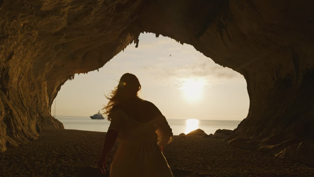 一个女人在沙滩上跑步的SLO MO视图，Cala Luna，撒丁岛，意大利。视频下载