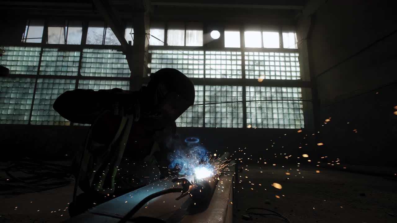工厂工人用焊机焊接金属的特写镜头。慢动作镜头视频下载