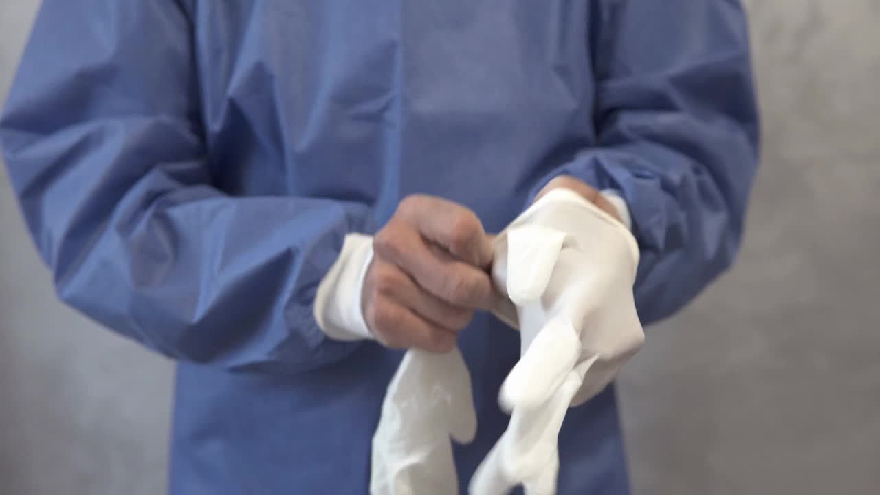 医生在让病人接种疫苗之前戴上一次性手套。视频下载