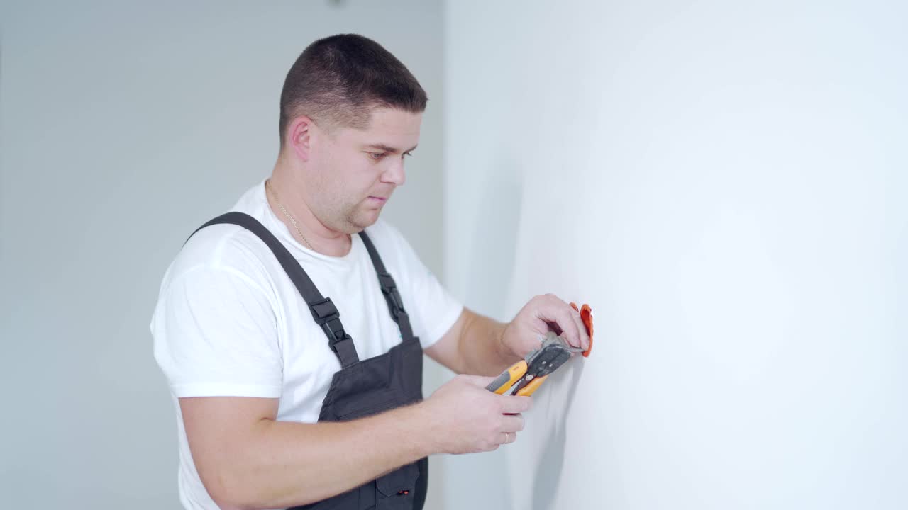男工人专业合格电工维修后在公寓安装插座视频素材