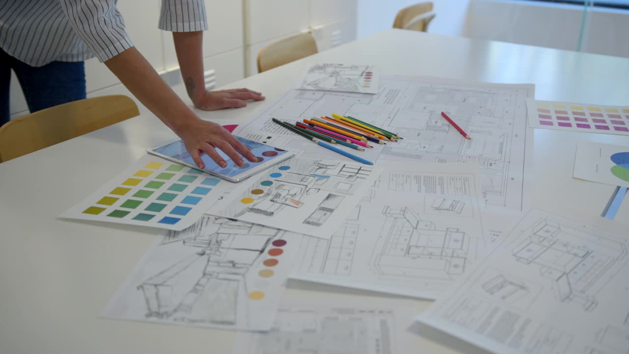 不知名的室内设计师在办公室用平板电脑和彩色铅笔绘制不同的草图视频下载