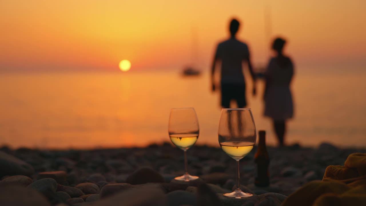 一对情侣在夕阳西下的意大利厄尔巴岛海边放松。视频下载