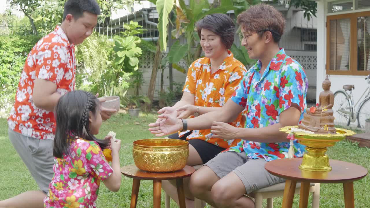 孩子们将水倒在受人尊敬的长者的手上，并用泰国书法泼水节祈求祝福视频下载