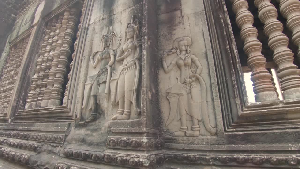 在柬埔寨吴哥窟(Angkor Wat)的一个寺庙画廊的立面上，有三个女人的照片视频下载