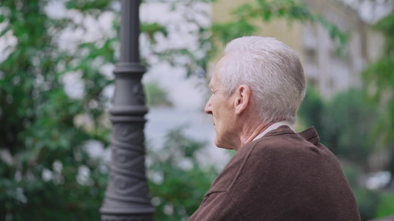 白发苍苍的老人坐在公园的长椅上，孤独的退休，悲伤的离去视频素材