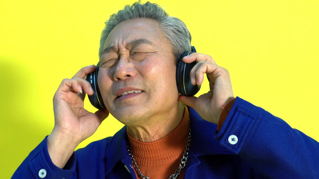 快乐的老人戴着耳机听音乐视频素材