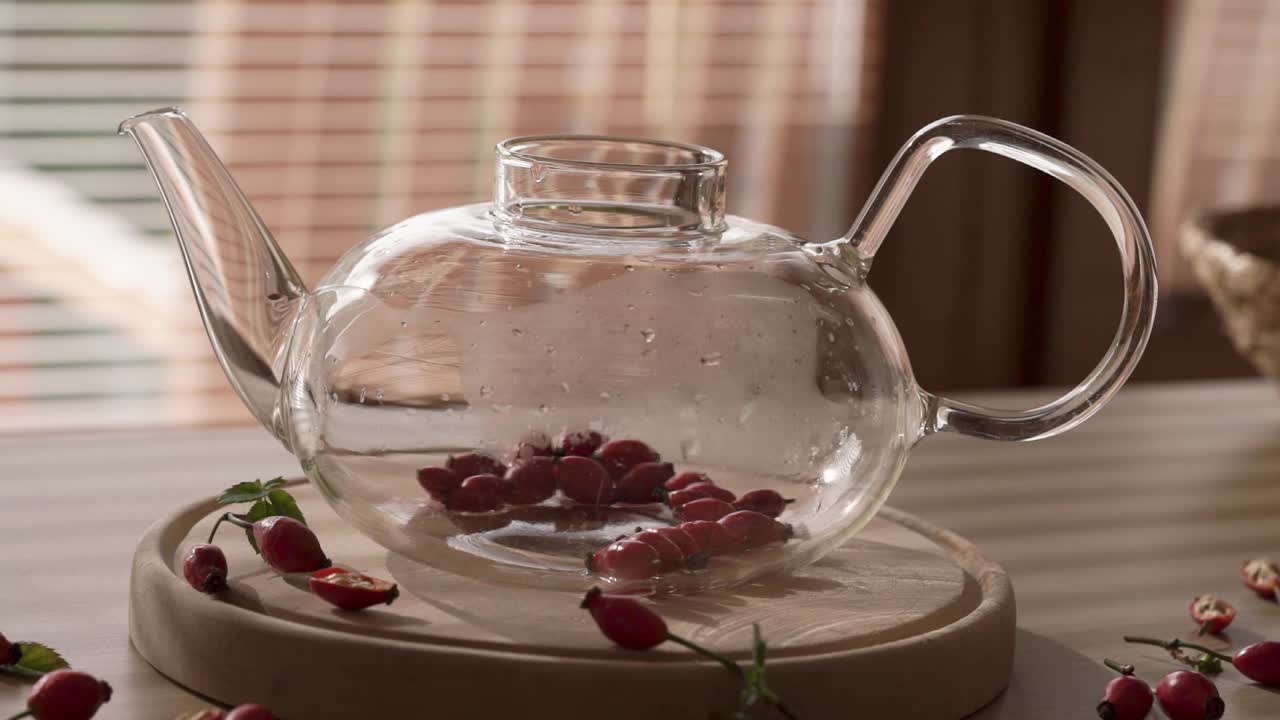 将热水倒入透明的玻璃茶壶中，即可沏出新鲜的玫瑰果茶视频下载