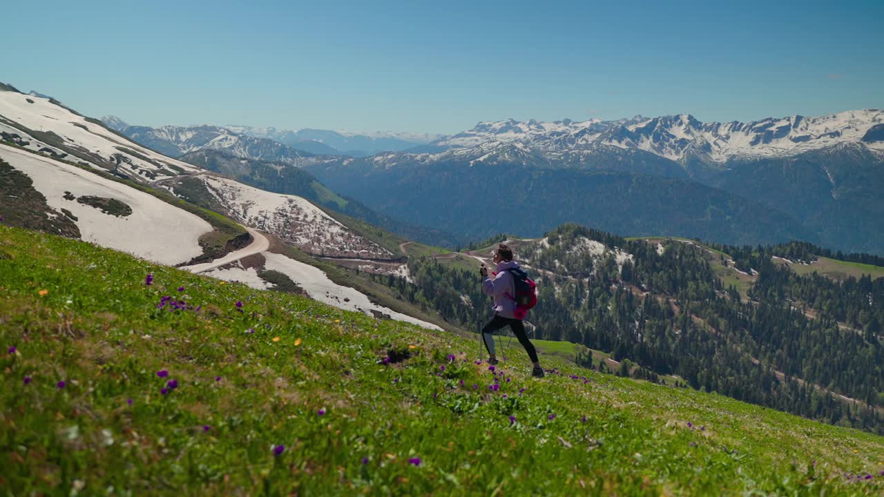 女徒步旅行者在绿色和雪山风景视频素材