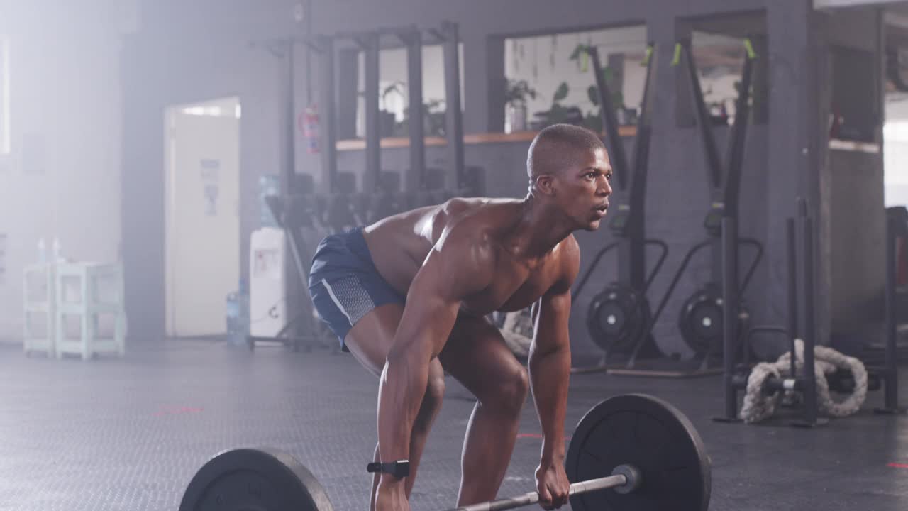 一个年轻肌肉男在健身房举杠铃的4k视频视频素材