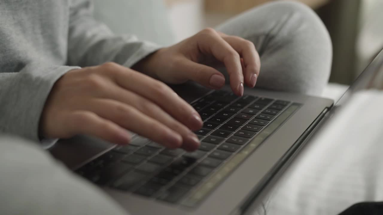 一个面目全非的女人用手在笔记本电脑键盘上打字视频素材