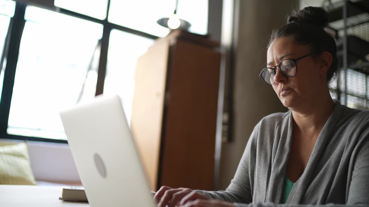 成熟的女人在工作时使用笔记本电脑视频素材