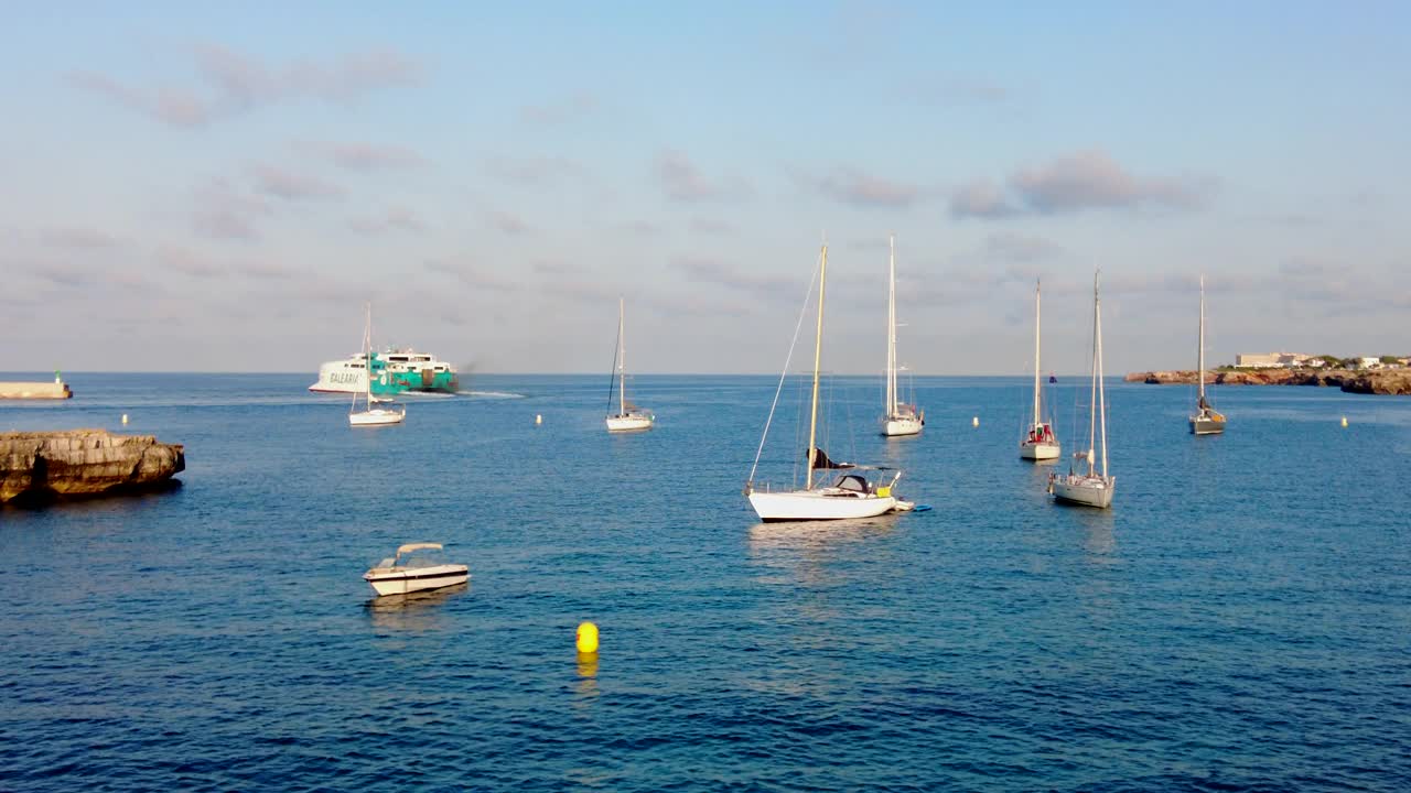 Ciutadella岩石海岸附近的帆船和渡船视频下载