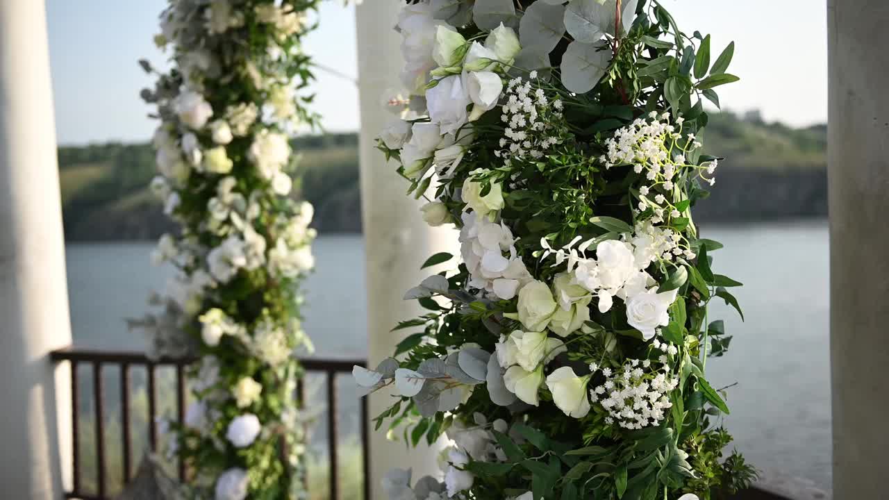优雅的婚礼拱门，鲜花，河流背景上的花瓶视频素材