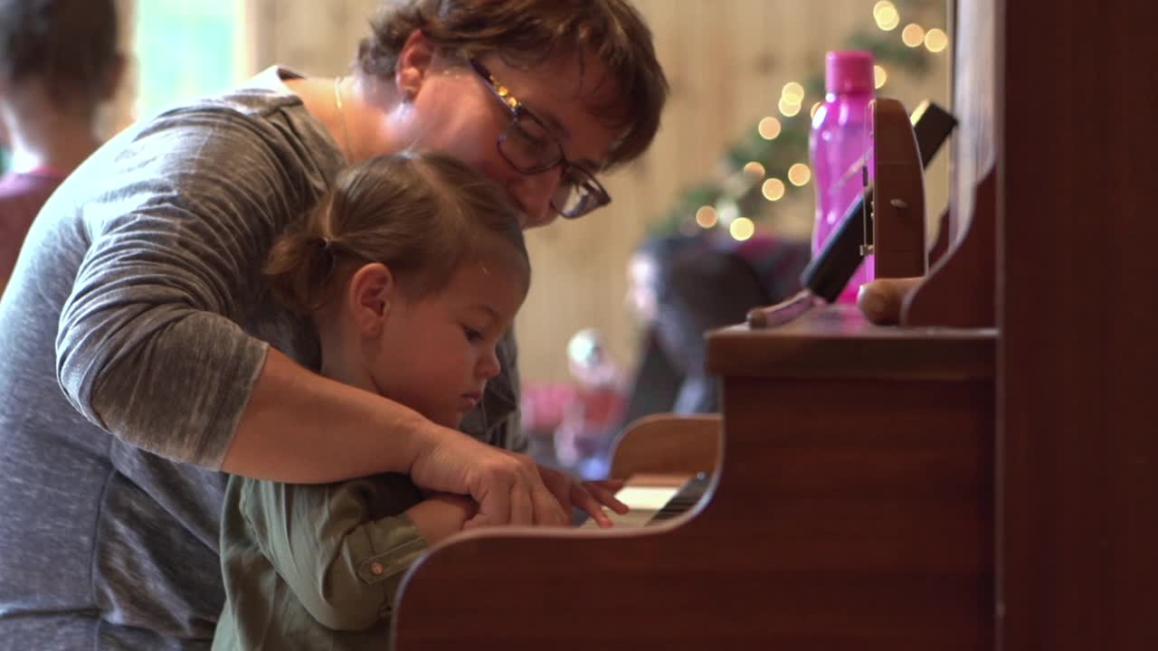 圣诞节美国大家庭庆祝祖母和孙女弹钢琴视频下载
